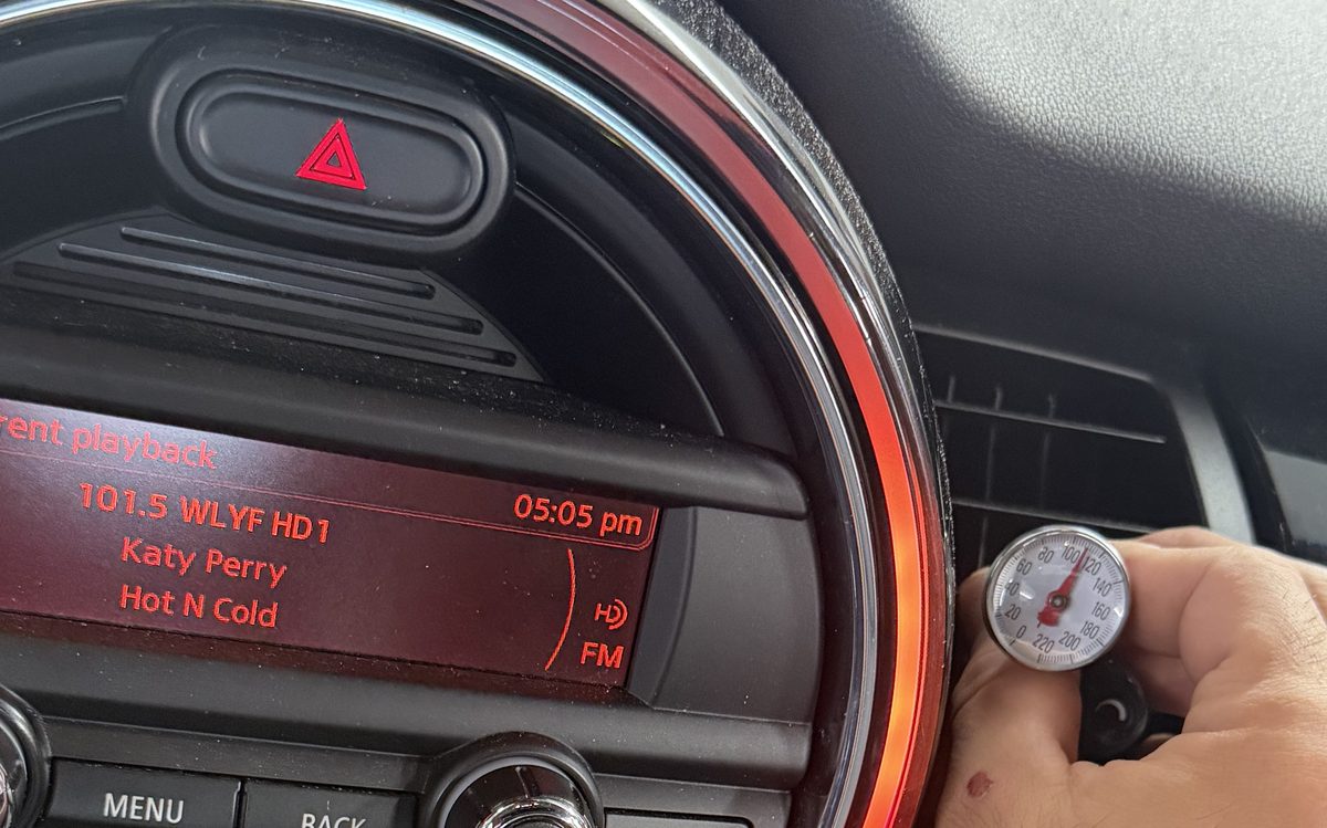 Technician checking car A/C vent temperature in Doral, FL